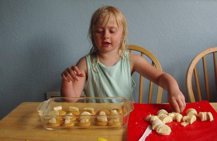 Una niña cocinando galletas con plátano