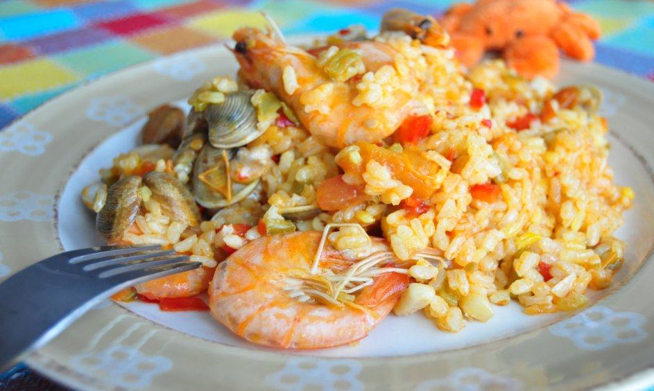 Paella marinera en su plato, con langostinos, calamares y chirlas