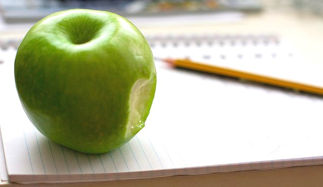 Una manzana mordida sobre un escritorio de trabajo